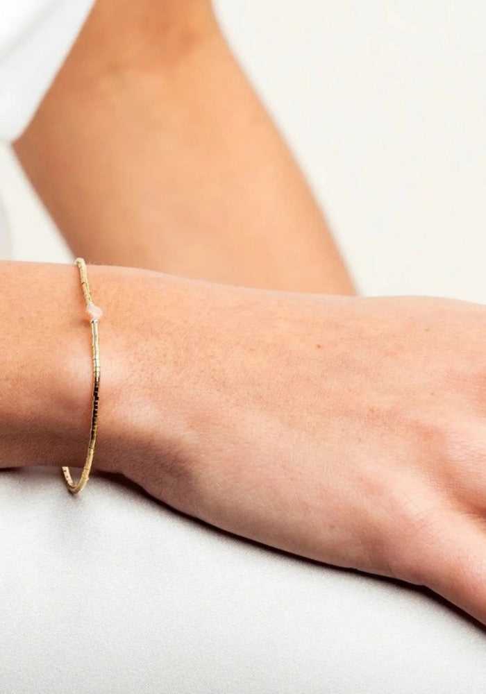 Bracelet fin en or laminé et pierre du soleil porté - Têtes Blondes