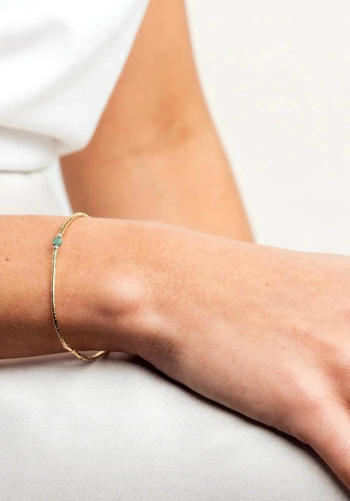 Bracelet fin en or laminé et turquoise africaine porté - Têtes Blondes